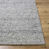 Close-up of the hand-tufted Winta Charcoal Wool Area Rug showing its texture and ash, gray, and silver gray colors. Front