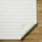 Close-up of Aurex Cream Stepped Arch Art Deco Wool Rug showing texture and hand-knotted construction on wood floor. Fold
