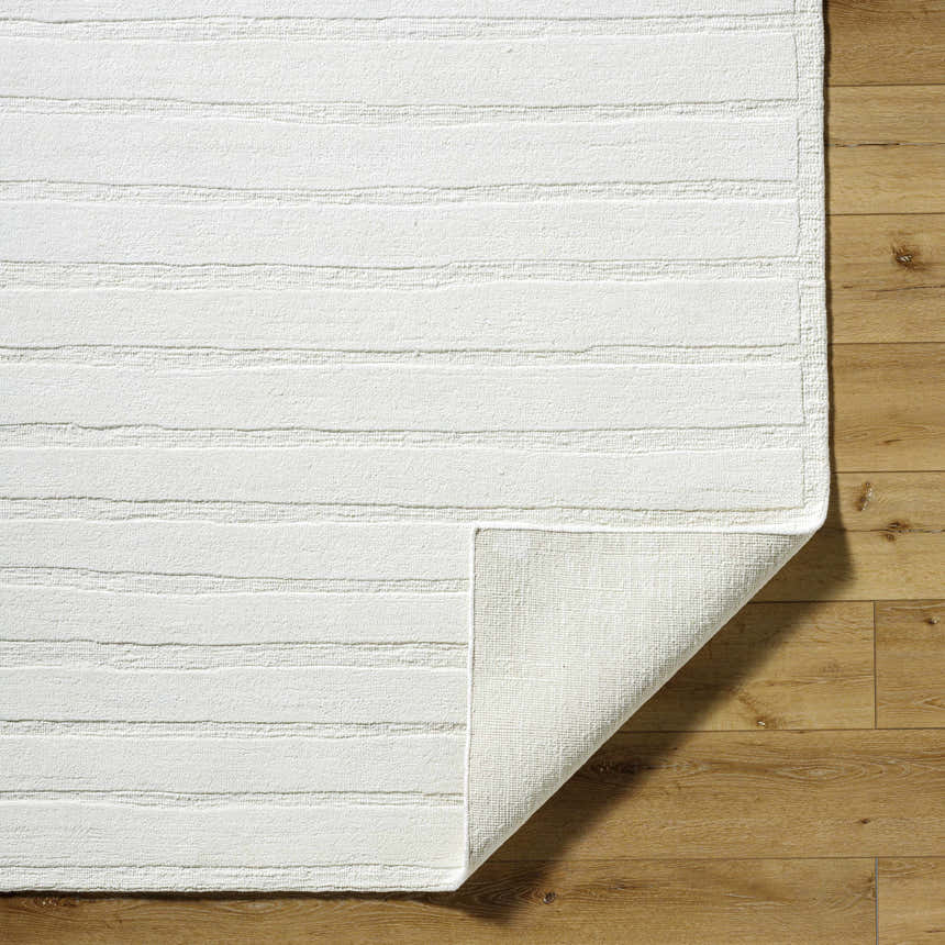 Close-up of Aurex Cream Stepped Arch Art Deco Wool Rug showing texture and hand-knotted construction on wood floor. Fold