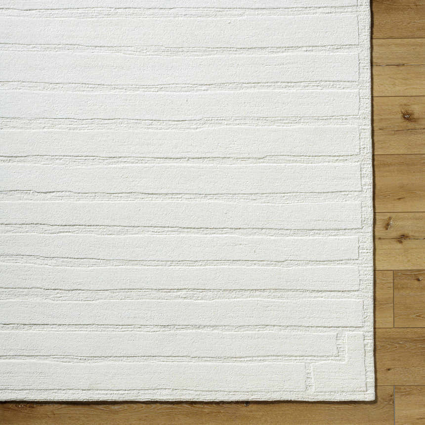 Close-up of the cream Aurex Stepped Arch Art Deco wool rug showing texture and stepped pattern on wood floor. Corner