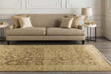 Living room scene with a tan sofa and the Lochmaben Premium Wool Rug in light brown and tan colors on a dark wood floor. Roomscene-Rectangle