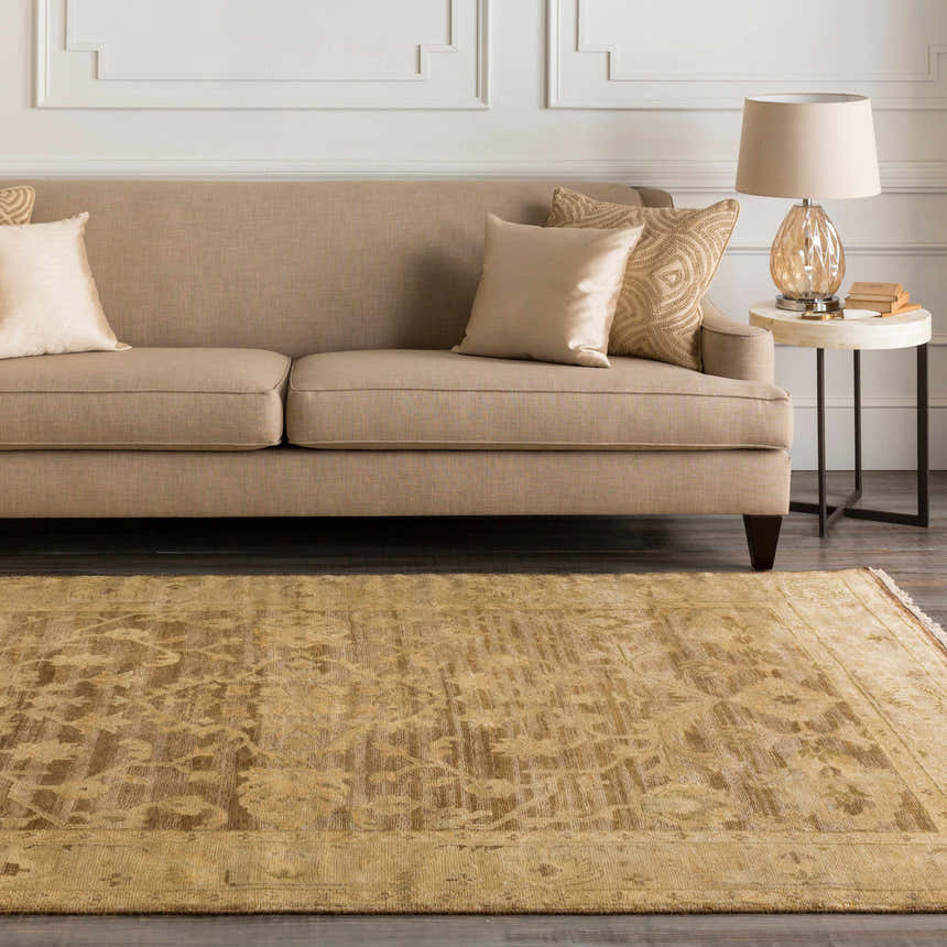 Living room scene with a tan sofa and a tan, floral Lochmaben Premium Wool Rug. Roomscene-Rectangle