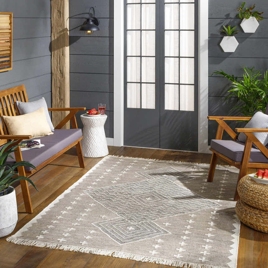 Cozy patio scene with a Lodwar Area Rug in charcoal, cream, and gray, wooden furniture, and modern decor. Roomscene-Rectangle