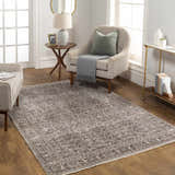 Living room scene with a charcoal Lugo Luxe Area Rug, beige armchairs, and light wood floors. Roomscene-Rectangle