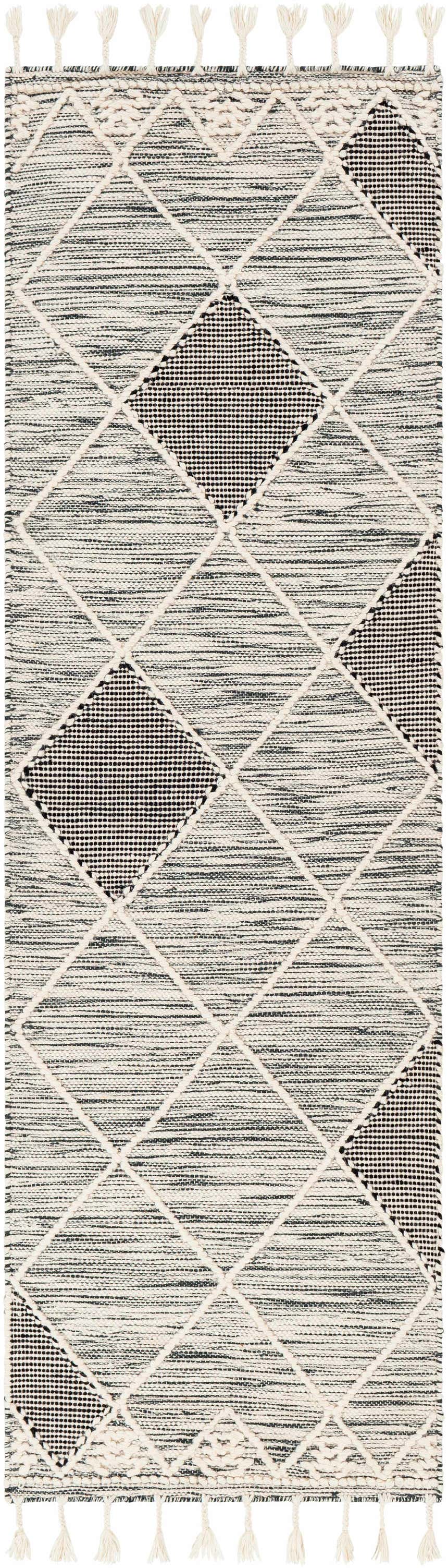 Close-up of Mabua Tasseled Jute&Wool Rug. Black geometric diamonds on cream wool with tassels. Hand woven rug texture. Design-Runner-268