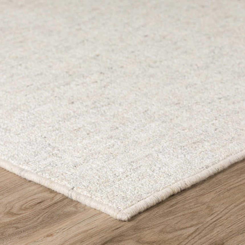 Close up of the ivory Dalyn Mateo Area Rug showing texture and detail on wood floor.