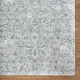 Close-up of the Melianna Gray Blue rug showing its traditional floral pattern and luxe texture on hardwood floor. Corner