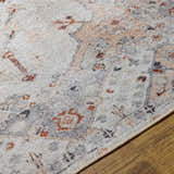 Close-up of Midtown Washable Area Rug. Brick red, charcoal, and gray oriental rug pattern on a wood floor. Texture