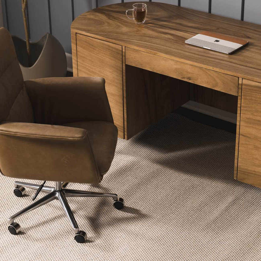 Home office scene with a light ivory Midha Area Rug, wood desk, and brown leather chair. Styleshot