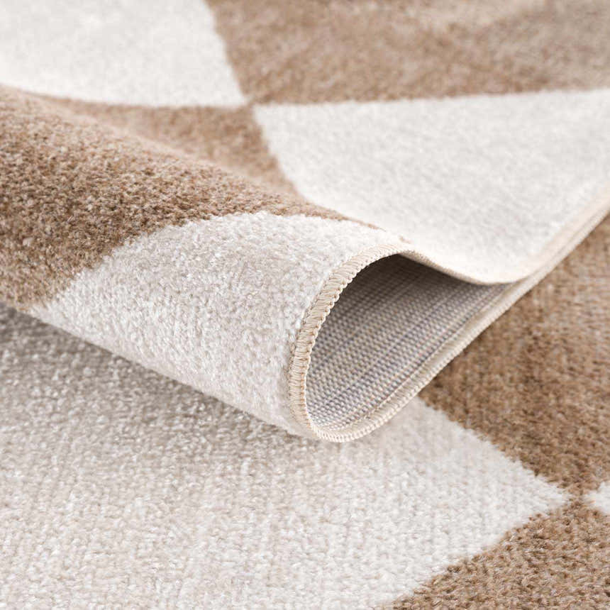 Close-up of the Ulric Brown Diamond Washable Area Rug showing its geometric pattern, soft texture, and durable machine-woven construction. Fold