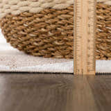 Close-up of the Ulric Brown Diamond Washable Area Rug showing the pile height with a ruler and a basket. Pile