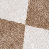 Close-up of the Ulric Brown Diamond Washable Area Rug showing its brown and cream geometric diamond pattern and soft texture. Texture
