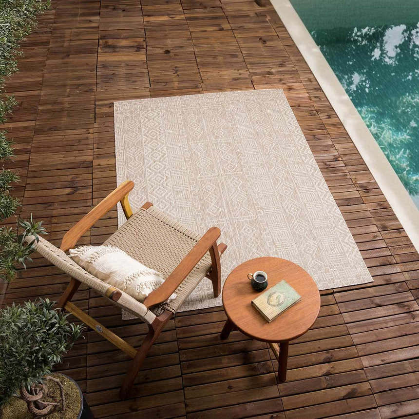 Outdoor patio scene with Epson Dark Beige Indoor & Outdoor Area Rug, chair, and side table by the pool. Roomscene-Rectangle