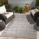 Outdoor patio scene with wicker furniture and the Naivasha area rug in charcoal, cream, and beige. Roomscene-Rectangle