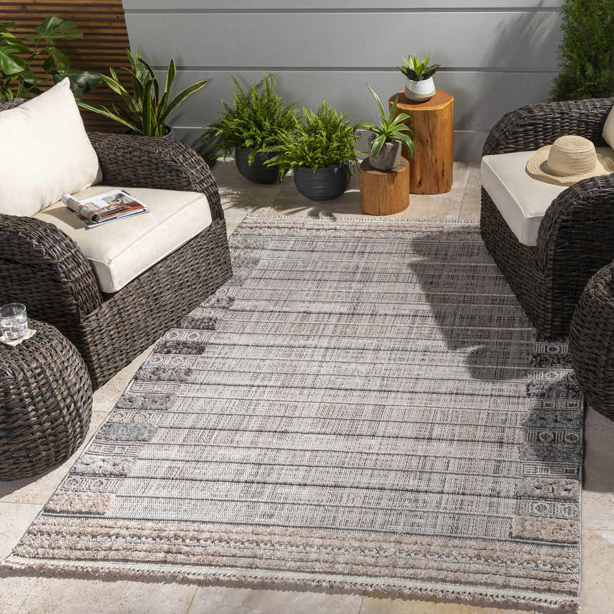 Outdoor patio scene with wicker furniture and the Naivasha area rug in charcoal, cream, and beige. Roomscene-Rectangle