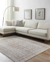 Living room with a cream couch and the Usonia Frank Lloyd Wright USO-2304 area rug in dark red, gray, and white. Roomscene-Rectangle