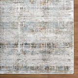 Close-up of the Neron Blue Gray Rug. Abstract design with charcoal, cream, brown, and blue gray hues. Luxe texture. Corner