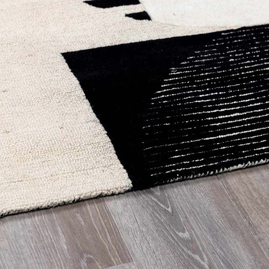 Close-up of the hand-tufted Brooklyn Modern wool rug. Features a geometric black and cream design with a textured pile. Pile