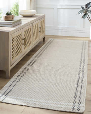 Living room scene with a light beige Nimue Area Rug, wood floors, and a console table. Roomscene-Runner
