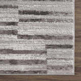 Close-up of the Arissa Broken-Striped Area Rug, a geometric design in black, gray, and white polyester. Swatch