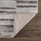 Close-up of Arissa Broken-Striped Area Rug showing black, gray, and white geometric pattern and rug backing. Fold