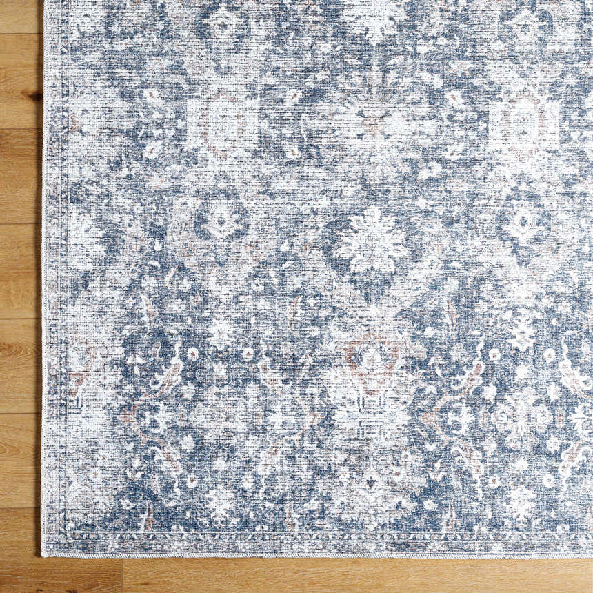 Close-up of the Arnaud Washable Area Rug. Beige and navy farmhouse style rug with a traditional floral pattern. Swatch