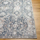 Close-up of the Arnaud Washable Area Rug. Beige, navy, and brown traditional pattern on a textured polyester rug. Front