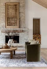 Living room scene with stone fireplace, olive chairs, and beige and navy Arnaud Washable Area Rug. Roomscene-Rectangle