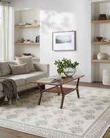 Living room with a sofa, wood coffee table and Aquene Ivory Washable Area Rug with blush, sage, and sky blue floral pattern. Roomscene-Rectangle