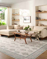 Living room scene with a neutral sofa and Aquene Ivory Washable Area Rug featuring blush, sage, and sky blue floral pattern. Roomscene-Rectangle