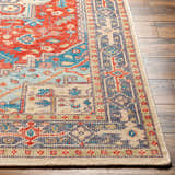 Close-up of the Oracabessa Premium Area Rug. Hand-knotted wool rug with a traditional Persian design in blue, red, and beige tones. Front