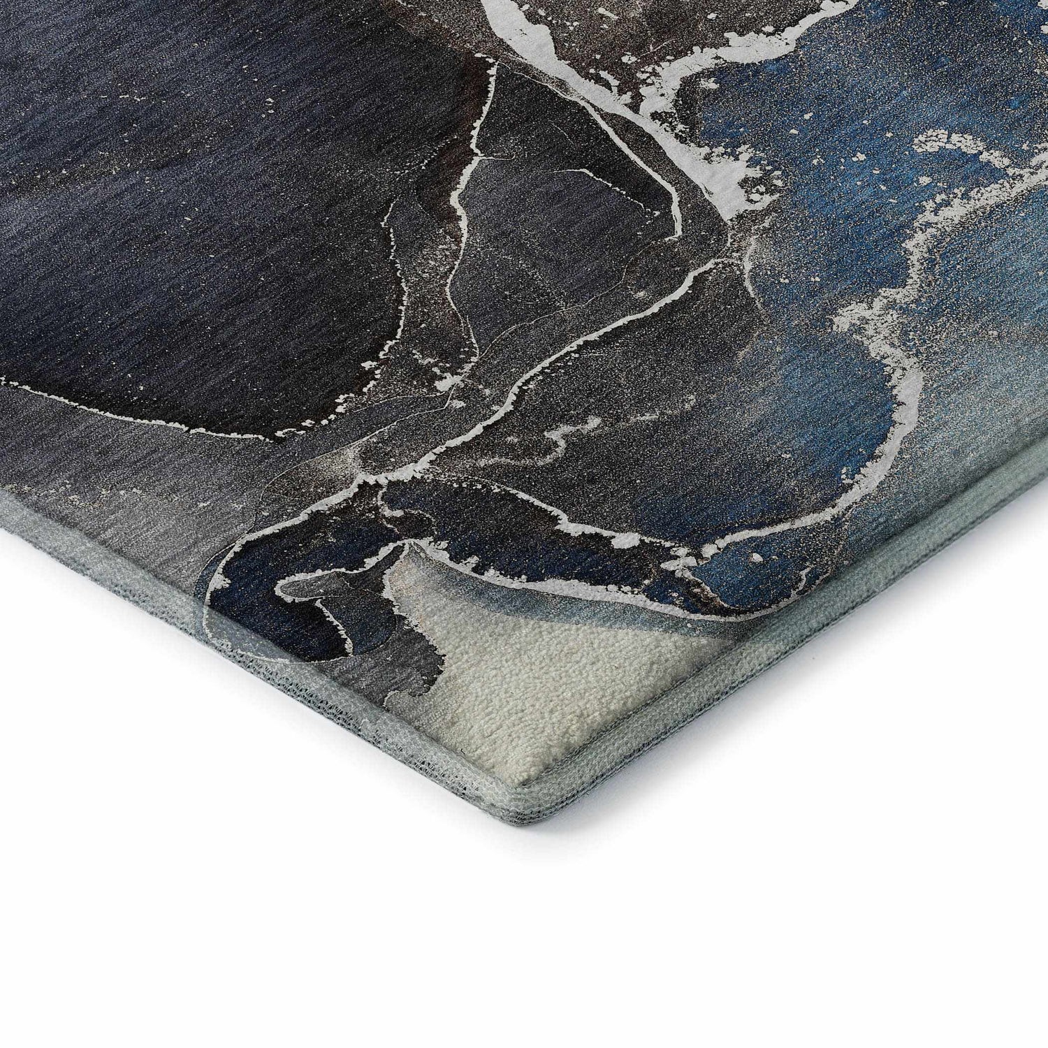 Close-up of Dalyn Luxury Odyssey rug. Blue, navy, and ivory abstract pattern with a non-skid backing.