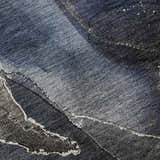 Close-up of the Dalyn Luxury Odyssey OY3 Blue Washable Area Rug, showing a textured blend of navy, light blue, and ivory.