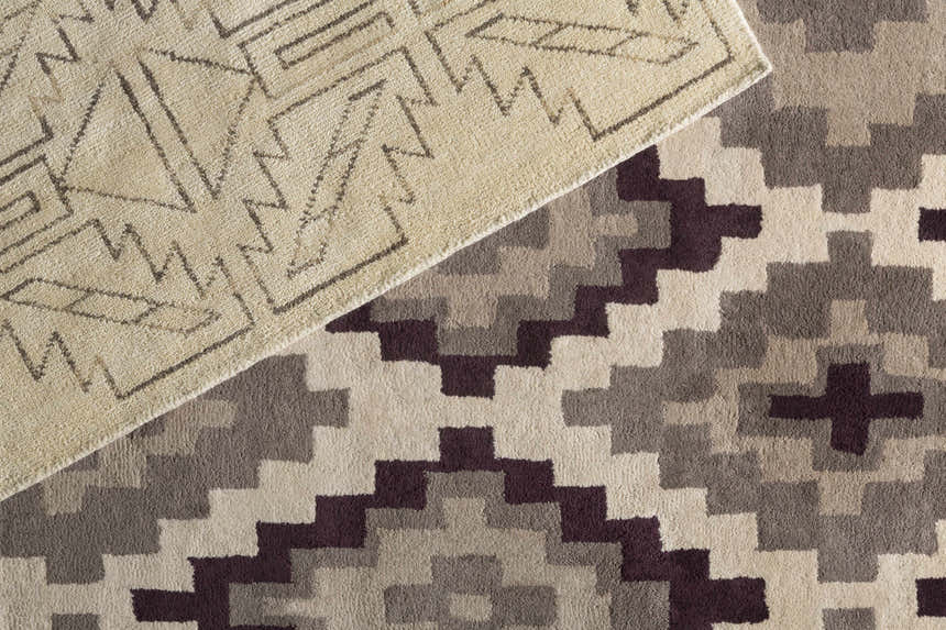 Close-up of the Pawhuska Area Rug. Features traditional geometric patterns in charcoal, peach, and cream tones. Hand-knotted wool texture. Styleshot