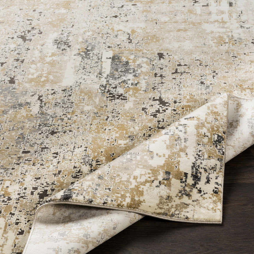 Close-up of Pewamo Area Rug showing beige, tan, charcoal, and black contemporary design on dark wood floor. Fold