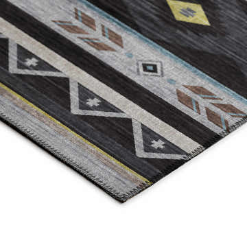 Close-up of the Dalyn Phoenix PH3 Black Washable Area Rug. Southwestern style with black, gray, gold, and blue geometric patterns.
