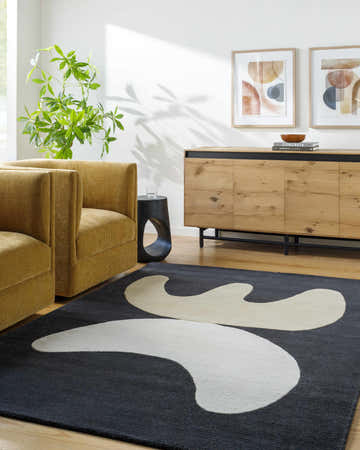 Contemporary living room with yellow armchairs and the Antoon Area Rug, a gray wool rug with a cream abstract design. Roomscene-Rectangle