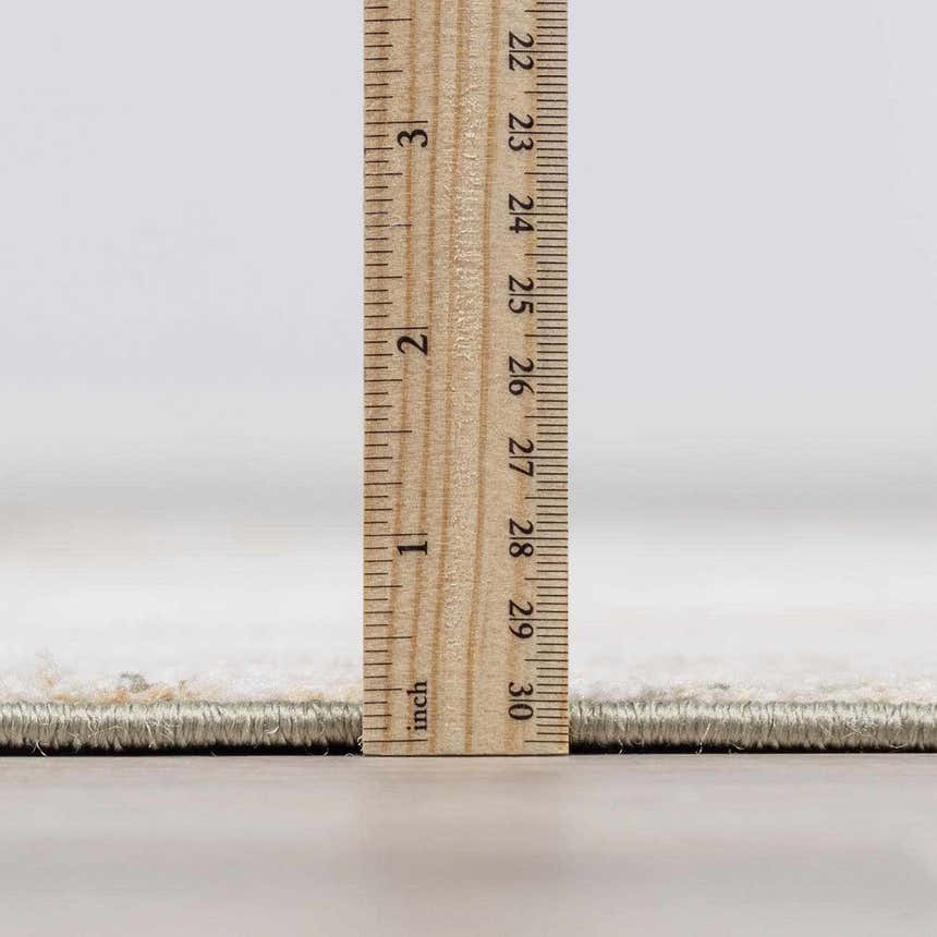 Close-up of Galey Alix x Livabliss Abstract Modern Marble Cream Myrtle Avenue III Area Rug thickness with ruler. Pile