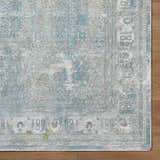 Close-up of the Pryce Blue Gray rug showing the traditional pattern, soft texture, and charcoal, cream, and light gray colors. Corner
