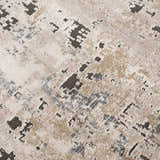 Close-up of the Pewamo Area Rug showing its abstract pattern in black, charcoal, beige, and tan. Texture