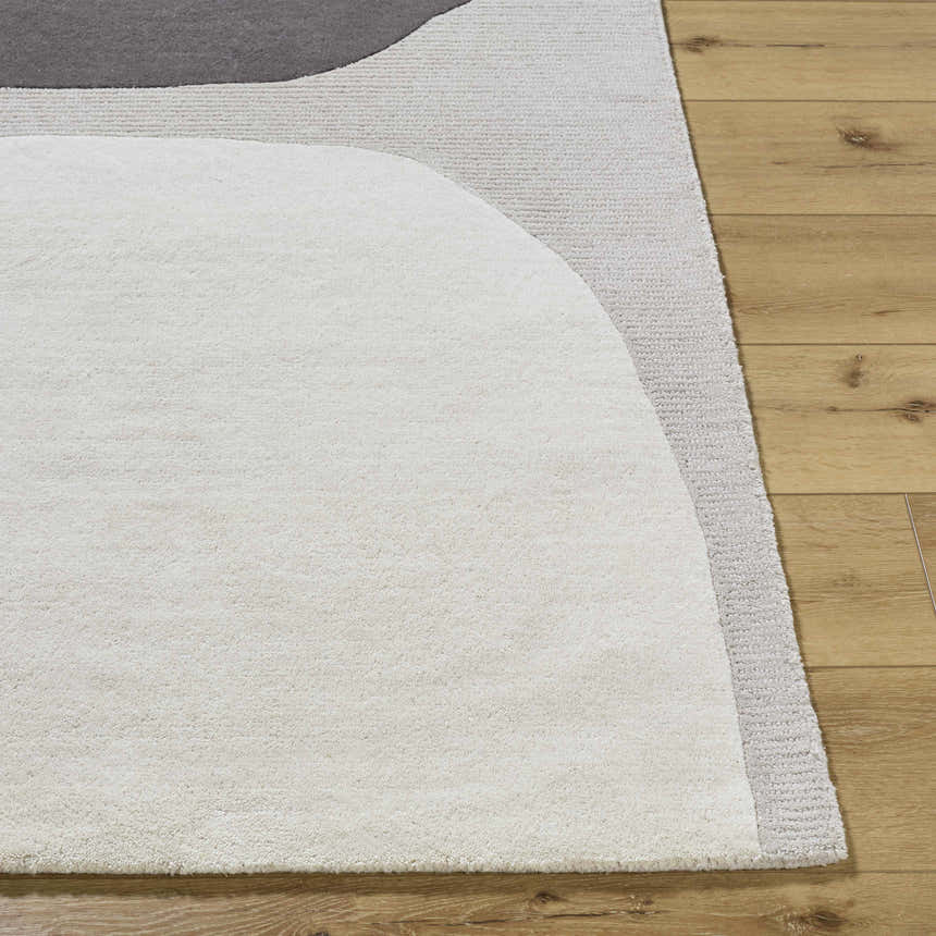 Close up of the hand tufted Adhara Area Rug featuring dark purple, medium gray and sterling gray wool. Front