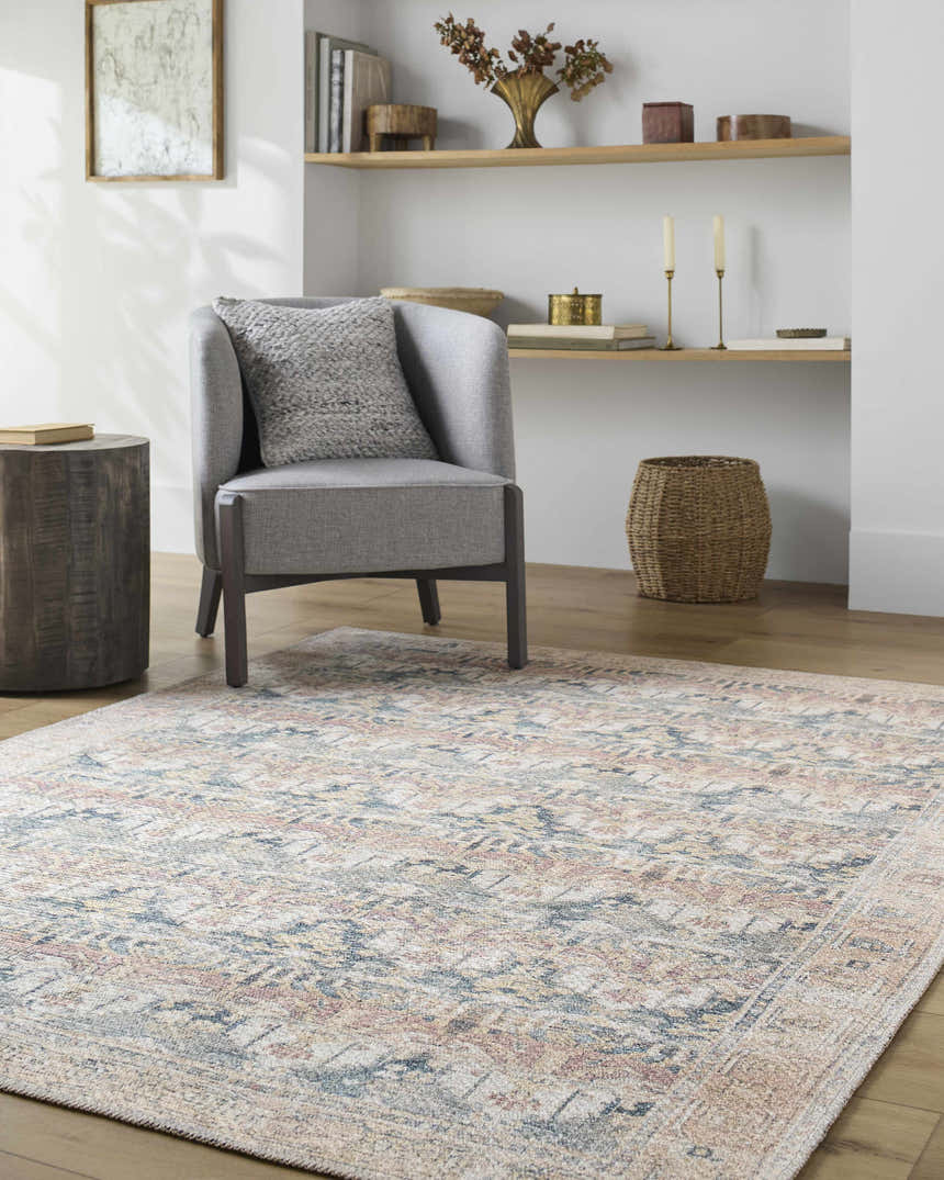 Living room scene with gray chair and Arushi Washable Area Rug in cream, green, orange, and rust tones. Roomscene-Rectangle