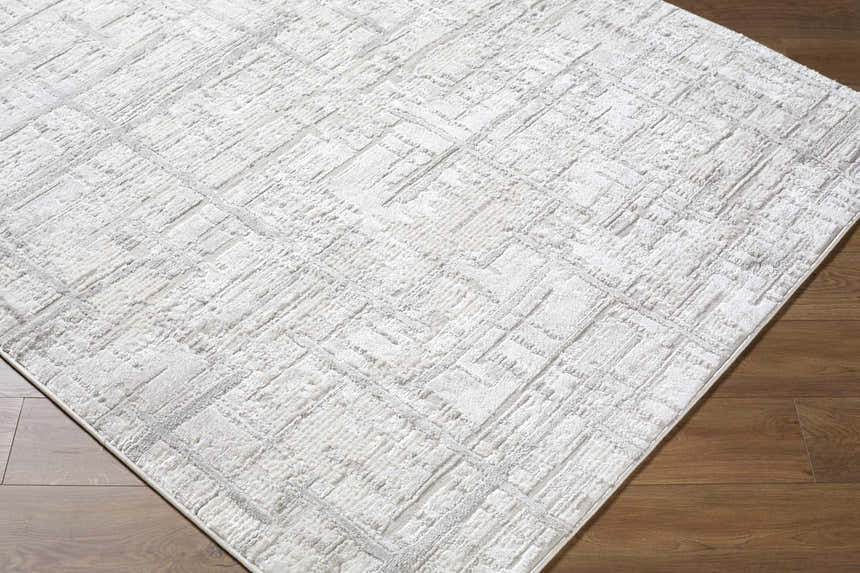 Close-up of the Antony Area Rug. Cream, ivory, and light gray contemporary design with a subtle geometric pattern. Corner
