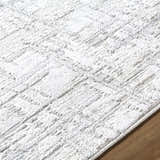 Close-up of the Antony Area Rug featuring a textured geometric pattern in cream, ivory, light gray, and white. Texture