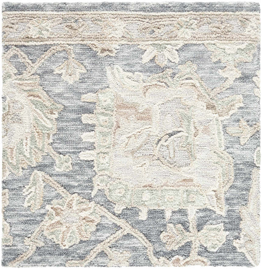 Close-up of the Auryon Hand Tufted Oushak Wool Area Rug showing off white and slate blue floral pattern and wool texture. Swatch