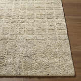 Close-up of the hand-tufted Asahel Ivory Area Rug showing wool texture and farmhouse style on wood floor. Front