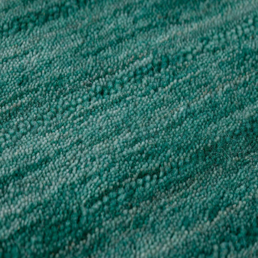 Close-up of the Dalyn Rafia RF100 Emerald area rug, showing its light green wool texture and hand-loomed construction.