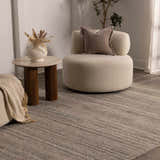 Neutral room scene with a Capote Tan Area Rug, round chair, and side table with vase. Roomscene-Rectangle
