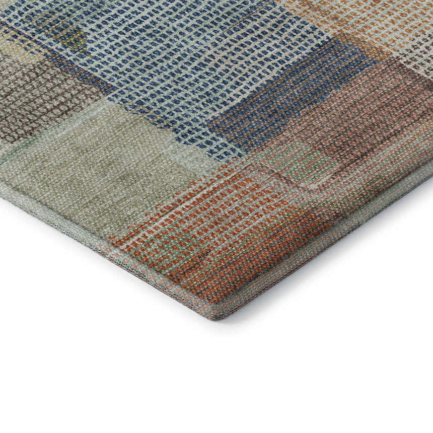 Close-up of the Dalyn Luxury Ravenna RN10 Putty Washable Area Rug featuring a geometric, patchwork design in beige, blue, coral, and green.
