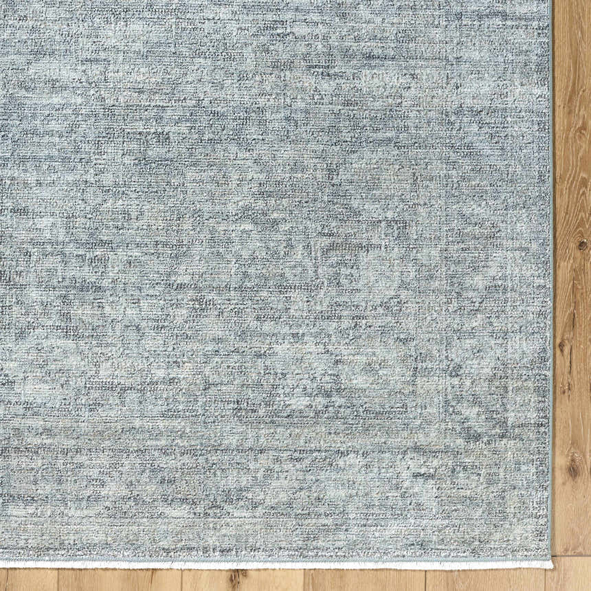Close-up of Livabliss x Galey Alix Maria Elena II rug. Vintage medallion pattern in cream, black, and gray on wood floor. Corner